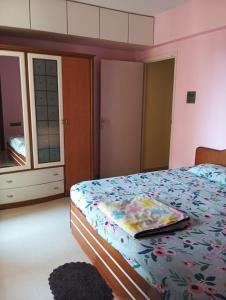 a bedroom with a bed with a floral comforter at Upscale 2BHK In Western Suburb in Mumbai