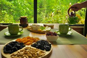 a table with a plate of food and cups of coffee at Nahei Cottage Martvili in Martvili