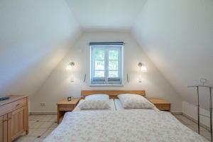 a attic bedroom with a bed and a window at Landhausvilla Wolsroi in Steinbergkirche