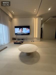 a living room with a coffee table and a flat screen tv at 樵築包棟民宿 唱歌電動麻將 2025年6月全新裝潢 in Yuanshan