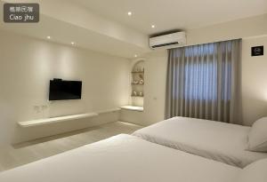 a white bedroom with a bed and a tv at 樵築包棟民宿 唱歌電動麻將 2025年6月全新裝潢 in Yuanshan