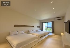 two beds in a room with a tv and a window at 樵築包棟民宿 唱歌電動麻將 2025年6月全新裝潢 in Yuanshan