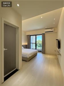 a bedroom with a bed and a large window at 樵築包棟民宿 唱歌電動麻將 2025年6月全新裝潢 in Yuanshan