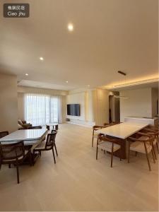 a living room with tables and chairs and a kitchen at 樵築包棟民宿 唱歌電動麻將 2025年6月全新裝潢 in Yuanshan