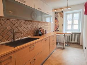 a kitchen with a sink and a table at Essenze di Bosco - Alpine Stay Apartments in Predazzo