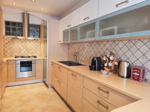 a kitchen with wooden cabinets and a counter top at Essenze di Bosco - Alpine Stay Apartments in Predazzo