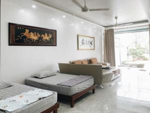 a bedroom with two beds and a couch at Pham'sHomestay in Île de Trà Cổ