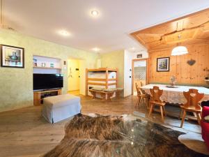 a large living room with a table and a tv at Essenze di Bosco - Alpine Stay Apartments in Predazzo