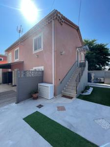 a pink house with a staircase in front of it at FREJUS port et base nature in Fréjus