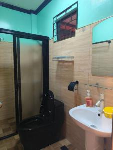 bagno con servizi igienici neri e lavandino di Little Apple Homestay near Paliton Beach Siquijor Island a San Juan