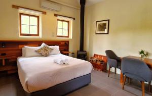 a bedroom with a bed and a desk and a table and chair at Bungaree Station in Clare +38 photos