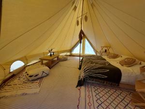 a room with a tent with a bed and a table at Glamping Luz Olive in Combret
