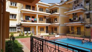 un hotel con piscina frente a un edificio en Baga Apartments Goa, en Calangute