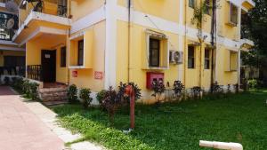 un edificio amarillo con un parquímetro delante de él en Baga Apartments Goa, en Calangute