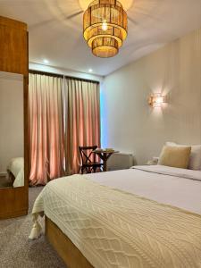 a bedroom with a bed and a chandelier at Palm Tbilisi Boutique Hotel in Tbilisi City