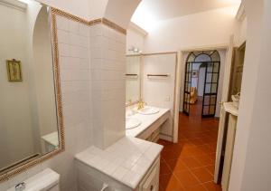 Un baño blanco con lavabo y espejo. en Appartamento in fattoria #2, en Pistoia