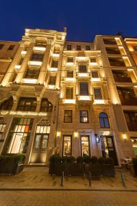 Un gran edificio con luces por la noche. en The Wings Hotels Pera, en Estambul