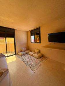 a living room with couches and a flat screen tv at Playa Surf House in Tamraght Ouzdar