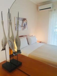 a bedroom with a bed with three birds on display at Sofia's modern apartment in Gjirokastër
