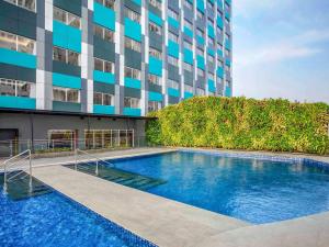 贝克西ibis Styles Bekasi Jatibening的建筑物前的游泳池