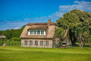 an old brick house on a grass field at Landhausvilla Wolsroi in Steinbergkirche
