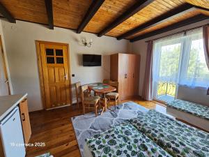 ヤストシェンビャ・グラにあるPokoje Goscinne Anna Mariaのベッドとテーブルとキッチンのある寝室