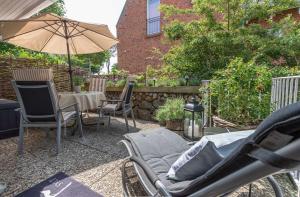 a patio with chairs and an umbrella and a table at Haus Gorch Fock Strasse in Westerland