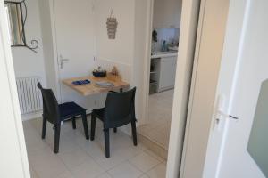 a small kitchen with a small table and chairs at Gîte 2 pers en studio indépendant chez l'habitant pour nuitée au calme et proche de la plage in Saint-Georges-de-Didonne