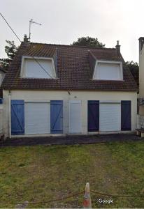 a house with blue and white garage doors at Le Marquenterre in Quend-Plage