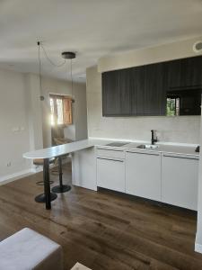 a kitchen with white cabinets and a table in it at La Barata Apartamentos in Colombres