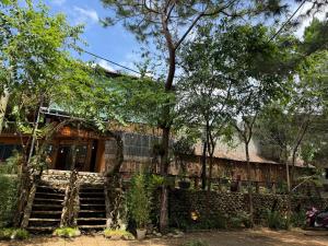 a building with stairs and trees in front of it at Thanh Bình Homestay Măng Đen 47 Trường Chinh in Kon Tum