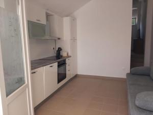 a small kitchen with white cabinets and a stove at Seaview apartment Lukić in Supetar +31 photos