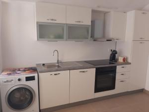 a kitchen with a washing machine and a sink at Seaview apartment Lukić in Supetar