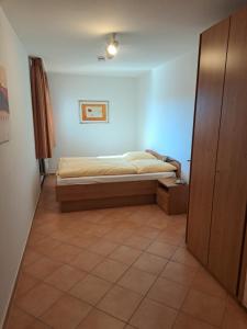 ein kleines Schlafzimmer mit einem Bett und Fliesenboden in der Unterkunft Haus Christianenhöhe App 40 in Westerland