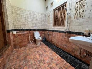 a bathroom with a toilet and a sink at Dream Village Jogja in Jarakan +34 photos
