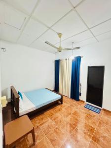 a bedroom with a bed and blue curtains in it at SuiteSpot Guest House in Anuradhapura