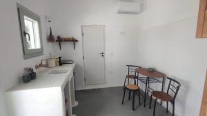 a kitchen with a sink and two stools at Salty Yard Holiday Home in Serifos Chora