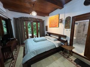 a bedroom with a bed and a table in it at Dream Village Jogja in Jarakan