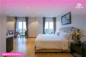 a hotel room with a bed and a bathroom at Infinity Pink Hotel Riverview in Danang