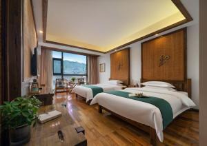 a bedroom with four beds in a room at Zhangjiajie Cloudscape Courtyard Hotel-Vegan Available, Chinese Retro Style,Tea Culture Experience, Free Breakfast ,Travel Guide& Book Tickets,Friendly Host,Orient esthetics in Hanqiyu