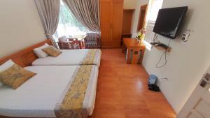 una camera da letto con due letti e una TV a schermo piatto di Villa 407 Eureka resort Linh Trường a Thanh Hóa