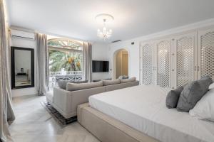 a white bedroom with a large bed and a couch at Palacio Suites Marbella in Marbella +85 photos