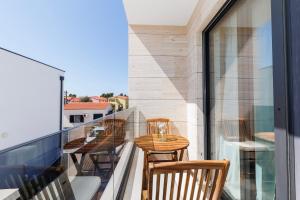a balcony with a wooden table and chairs on it at Villa Riva Vir Apartment in Vir