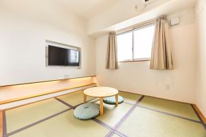 宮古島にあるSmile Hotel Miyakojimaのテーブルと薄型テレビのある部屋