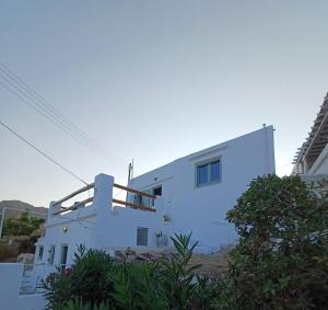 a white house with blue walls at Salty Yard Holiday Home in Serifos Chora