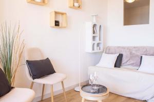 un salon avec deux chaises et un canapé dans l'établissement Appartement Cosy avec Vue Mer au 4e, à Valras-Plage