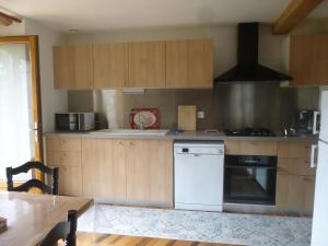 eine Küche mit Holzschränken und einem weißen Geschirrspüler in der Unterkunft la Metairie in Montvalent + 9 Fotos