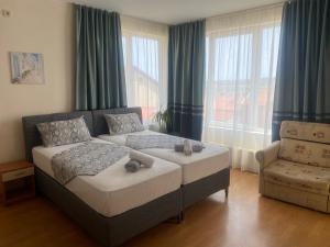 a bedroom with two beds and a couch and a chair at Guest house Eos in Sozopol