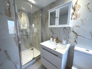 a white bathroom with a sink and a shower at Bubbles Bliss - Hot Tub Garden Pass the Keys in Rye +17 photos