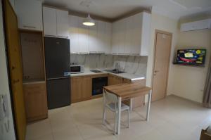 Polisi i VogëlにあるKaja Apartments ' Studio 'のキッチン(木製テーブル、カウンタートップ付)
